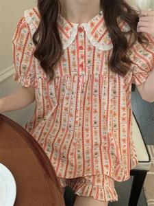Detail of cartoon bear print pajamas with lace Peter Pan collar and red buttons
