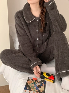 Detail of soft dark grey fleece pajama set featuring white contrast piping and button-down top