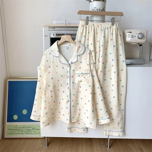 Détail d'un pyjama en coton crème à pois colorés avec une finition de bordure bleue