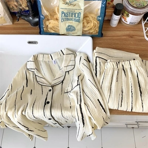 Flat lay of black and white striped pajama set with textured crinkle fabric on a table