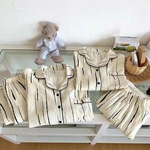 Detail of striped cream pajama set with matching teddy bear outfit on a table