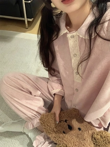 Détail d'un pyjama rose en polaire corail avec col en dentelle et boutons élégants