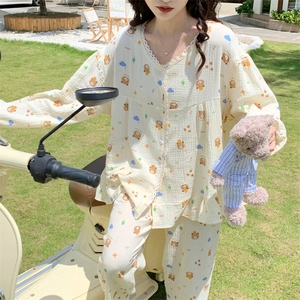 Detail of waffle knit bear pattern loungewear with lace V-neck trim on a vintage scooter