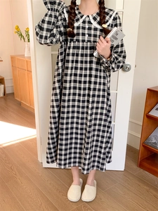 Detailansicht des Spitzenkragens und des schwarz-weißen Karomusters am Schlafkleid