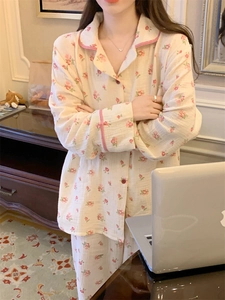 Détail d'un pyjama à fleurs avec bordure à carreaux et boutons rouges en décor cosy