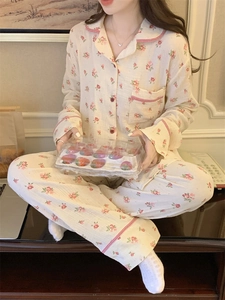 Détail du pyjama fleuri avec motifs de roses roses et liserés à carreaux rouges