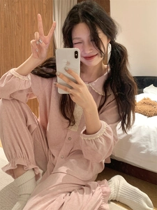 Détail d'un pyjama en polaire rose avec bordures en dentelle blanche et boutons sur le devant