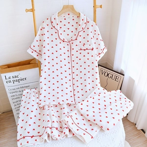 Close-up of soft white cotton pajamas with red heart prints and piping details