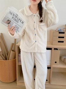 Detail of soft cream fleece pajamas featuring light blue piping and button-up lapel