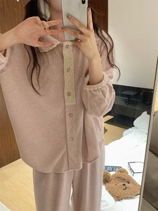 Détail d'un pyjama en polaire rose avec col en dentelle et boutons pour femme