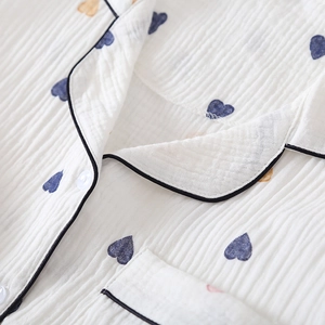 Close-up of white crepe cotton pajamas with blue and yellow hearts and black piping