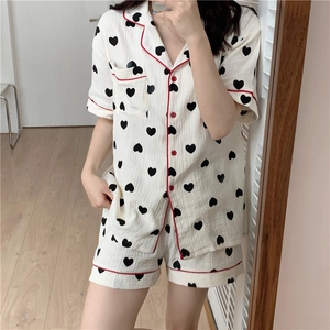 Detail view of cotton gauze heart pattern pajama set with red piping and chest pocket