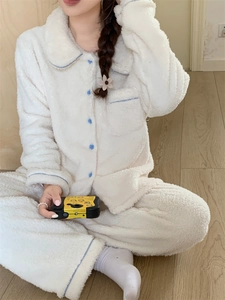 Detail of white double-sided plush pajamas with soft blue piping and button accents