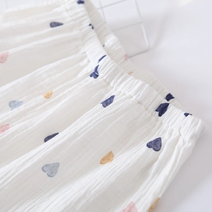Detail of white cotton gauze pajama shorts with elastic waistband and colorful heart prints