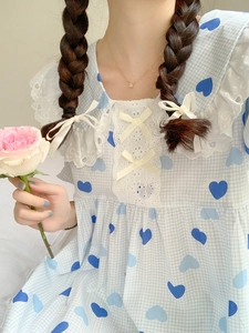 Dettaglio pigiama vintage francese con motivi a cuore, pizzo e fiocco giallo