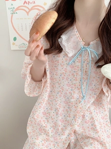 Dettaglio pigiama in chiffon a fiori con colletto in pizzo e decorazione con fiocco blu