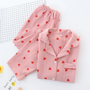 Detail of pink cotton pajama set with heart patterns and flower-shaped buttons