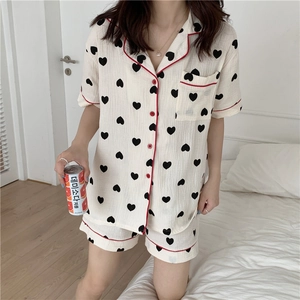 Detail of cotton gauze pajama set with heart print and red contrast piping