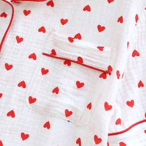 Detail of white cotton gauze pajama top with red heart pattern and piping on pocket