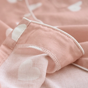 Detail of pink cotton pajamas featuring white heart print and high-quality edge stitching