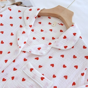Detail of white cotton crepe pajama shirt with red heart print and buttoned lapel collar