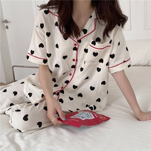Detail of white cotton heart-print pajama set with vibrant red piping and button closures