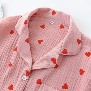 Close-up of pink cotton gauze pajamas with red heart prints and flower-shaped buttons
