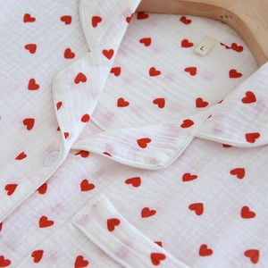 Detail of red heart prints on white cotton crepe pajama collar with white buttons