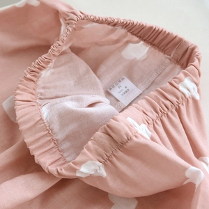 Detail of soft pink cotton pajama pants featuring a comfortable elastic waist and cloud pattern