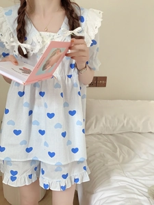 Dettaglio del pigiama a cuori blu con colletto in pizzo bianco e fiocco in nastro