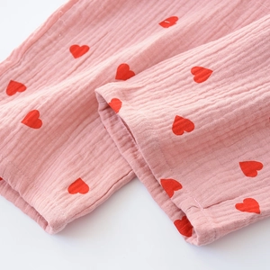 Detailed close-up of pink cotton gauze pajamas featuring small red heart prints