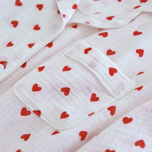 Detail of soft cotton crepe pajama top featuring red heart prints and a lapel collar