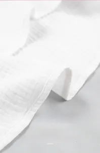 Detailed macro view of white double-layer gauze fabric showing fine stitching and texture