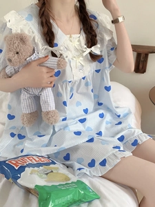 Dettaglio della camicia da notte a quadretti azzurri con pizzo e stampa a cuori
