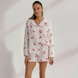 Detail of cotton pajama set with heart print featuring button-down collar and chest pocket