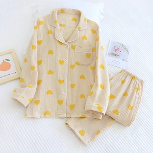 Détail de pyjama en coton crêpé avec motif de cœurs jaunes et passepoil blanc contrastant