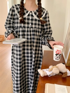 Nahaufnahme von schwarz-weißem Karo-Schlafanzugkleid mit Vintage-Spitzenkragen und Puppenhals