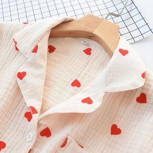 Close-up of heart pattern cotton pajama collar with flower buttons on wood hanger