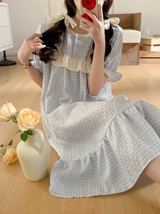 Détail de la chemise de nuit d'été à carreaux bleus avec dentelle et boutons