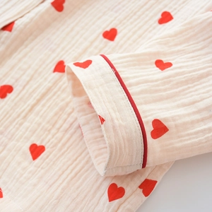 Detail of soft cotton double gauze sleeve with red heart print and refined piped edge