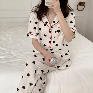 Detail of cotton gauze pajamas set with black heart print and red contrast piping trims