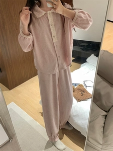 Détail du pyjama en polaire rose avec col Peter Pan et bordure en dentelle blanche