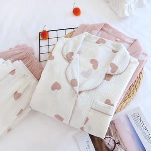 Vue détaillée du pyjama en coton gaze à motif de cœur sur un fond de lit confortable