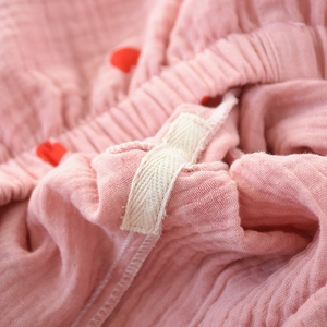 Detailed macro view of pink cotton crepe fabric with red hearts and elastic waistband