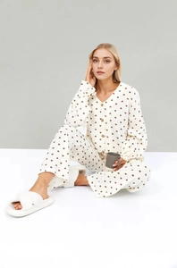 Détail de pyjama blanc en coton avec imprimé cœurs et boutons à texture de bois