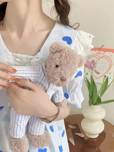 Dettaglio del tessuto vichy blu con stampe a cuore e pizzo bianco sul set pigiama