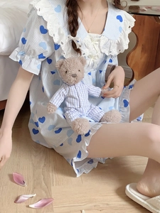 Dettaglio del set pigiama azzurro a cuori con colletto in pizzo e tenero orsetto di peluche