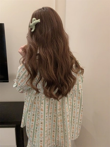 Detail view of cute cartoon bear print on striped pajamas with a green hair accessory