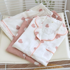 Detail of cotton pajama set with heart patterns and flower buttons on a metal chair