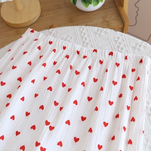 Close-up of heart pattern cotton pajamas pants with elastic waistband on a cozy lace mat